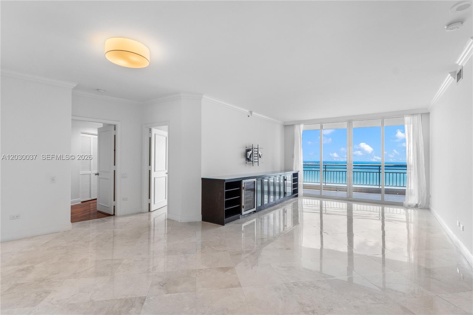 A bright living room features marble floors, a dark media console, and floor-to-ceiling ocean views — 808 Brickell Key Dr # 3002, Miami FL 33131, MIAMI, FL