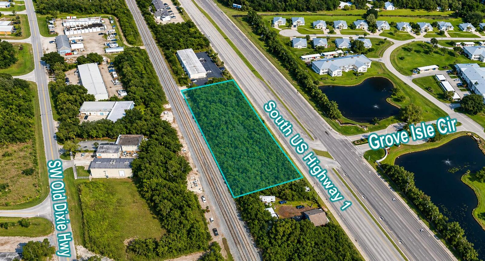 An aerial view shows a rectangular, tree-covered vacant lot situated between a highway and railroad — 1437 U.s. 1, Vero Beach FL 32960, VERO BEACH, FL