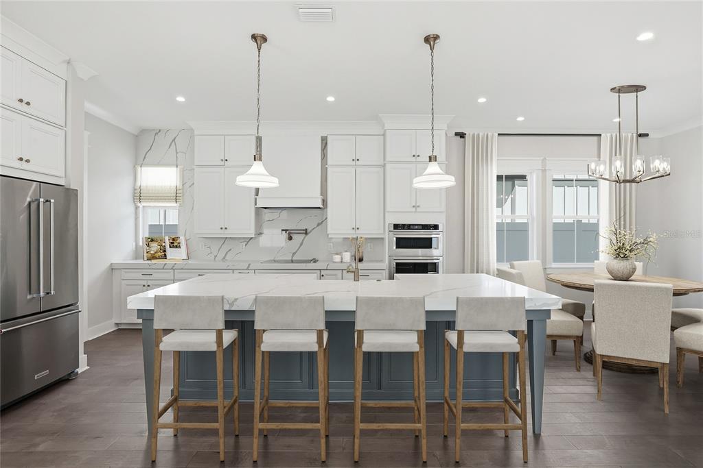 A kitchen features a large blue island, white cabinetry, marble countertops, and stainless steel appliances — 879 53RD AVENUE N, ST PETERSBURG, FL