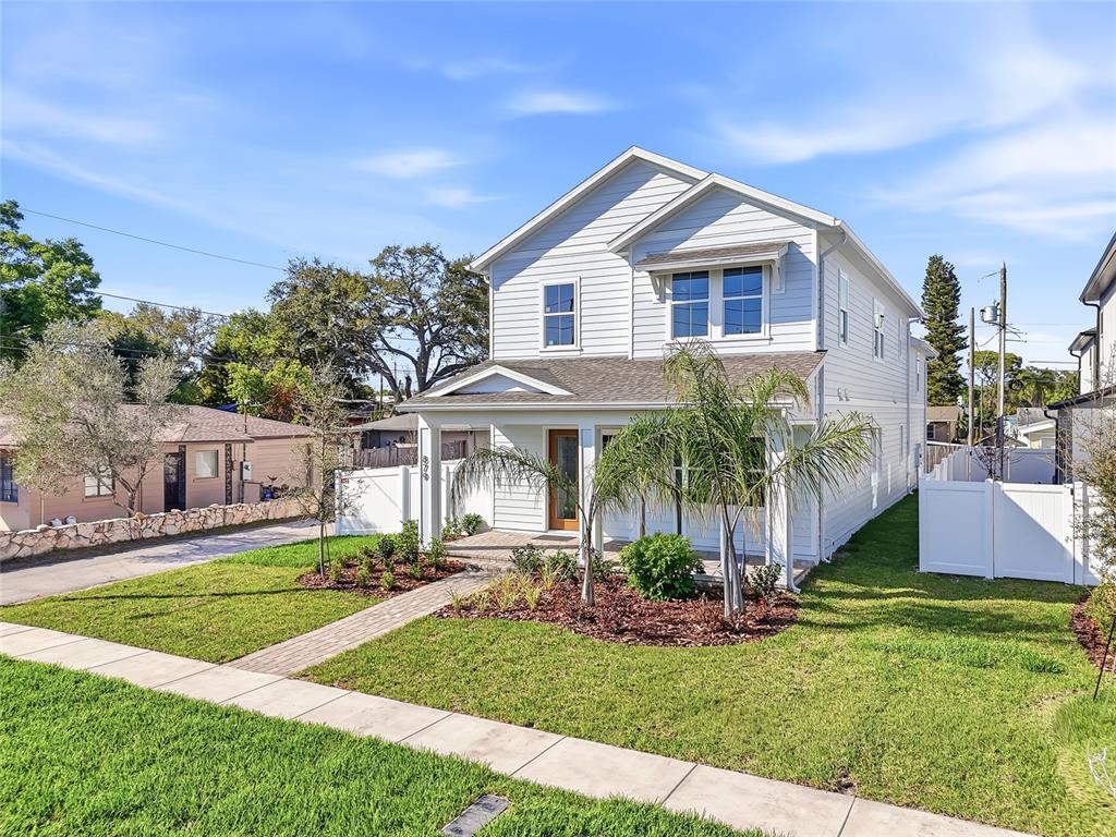 A two-story light blue house with a front porch and a brick walkway — 879 53RD AVENUE N, ST PETERSBURG, FL