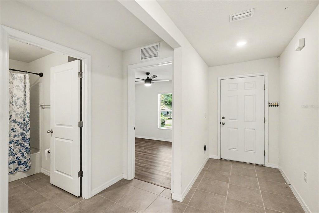A tiled entryway leads to a bathroom on the left and a bedroom beyond — 10213 CLOUDBURST COURT, RIVERVIEW, FL