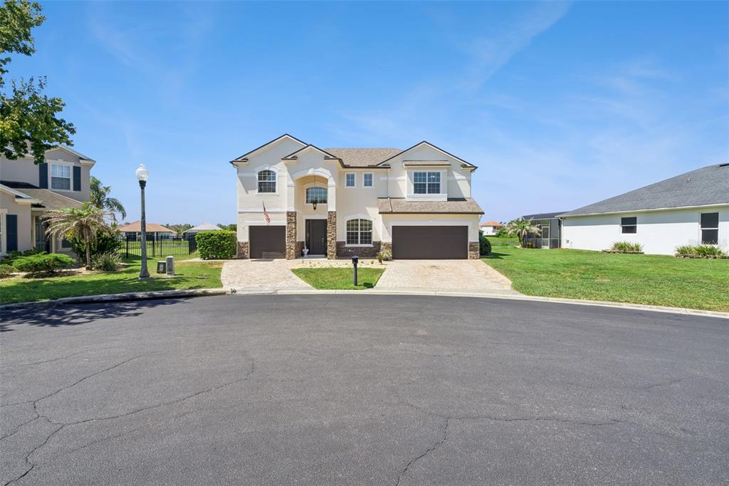 A two-story suburban house with a beige stucco exterior and two attached garages — 1531 LEXINGTON AVENUE, DAVENPORT, FL