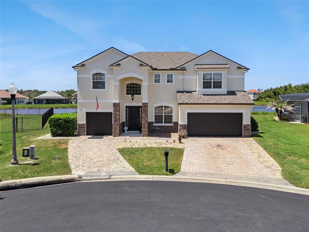 A two-story suburban house with a three-car garage and a paver driveway — 1531 LEXINGTON AVENUE, DAVENPORT, FL