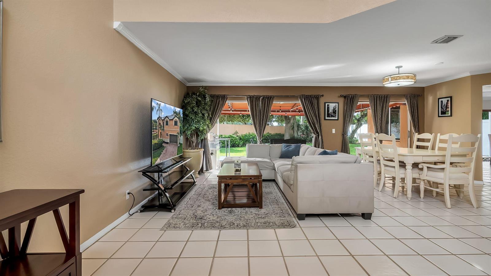 A living and dining area with tile floors, a sectional sofa, and sliding glass doors — 2510 Rampart Way S, Hollywood FL 33026, HOLLYWOOD, FL