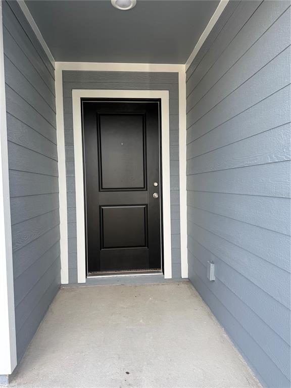 A covered entryway features a black front door surrounded by blue horizontal siding — 3463 ROVER ROAD, EAGLE LAKE, FL