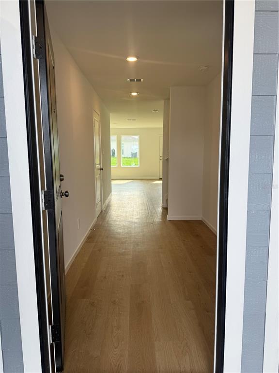 An entryway leads into a hallway with light wood-look flooring and recessed ceiling lighting — 3463 ROVER ROAD, EAGLE LAKE, FL