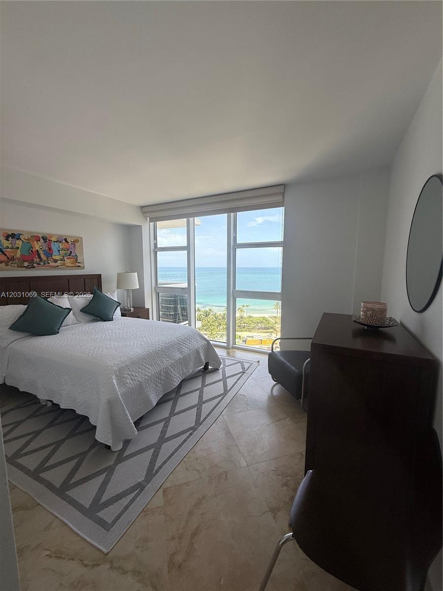 A bedroom features a bed, a dresser, and floor-to-ceiling windows overlooking the ocean — 10275 Collins Ave # 1221, Bal Harbour FL 33154, BAL HARBOUR, FL