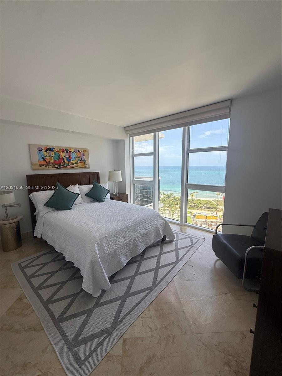 A bedroom with a bed, rug, and floor-to-ceiling windows overlooking the ocean — 10275 Collins Ave # 1221, Bal Harbour FL 33154, BAL HARBOUR, FL