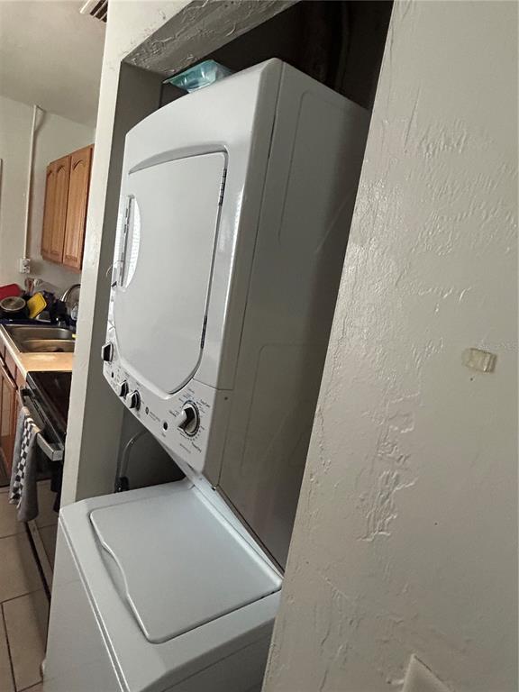 A stacked washer and dryer unit is positioned in a small alcove near a kitchen — 1220 NW 31 AVENUE, GAINESVILLE, FL