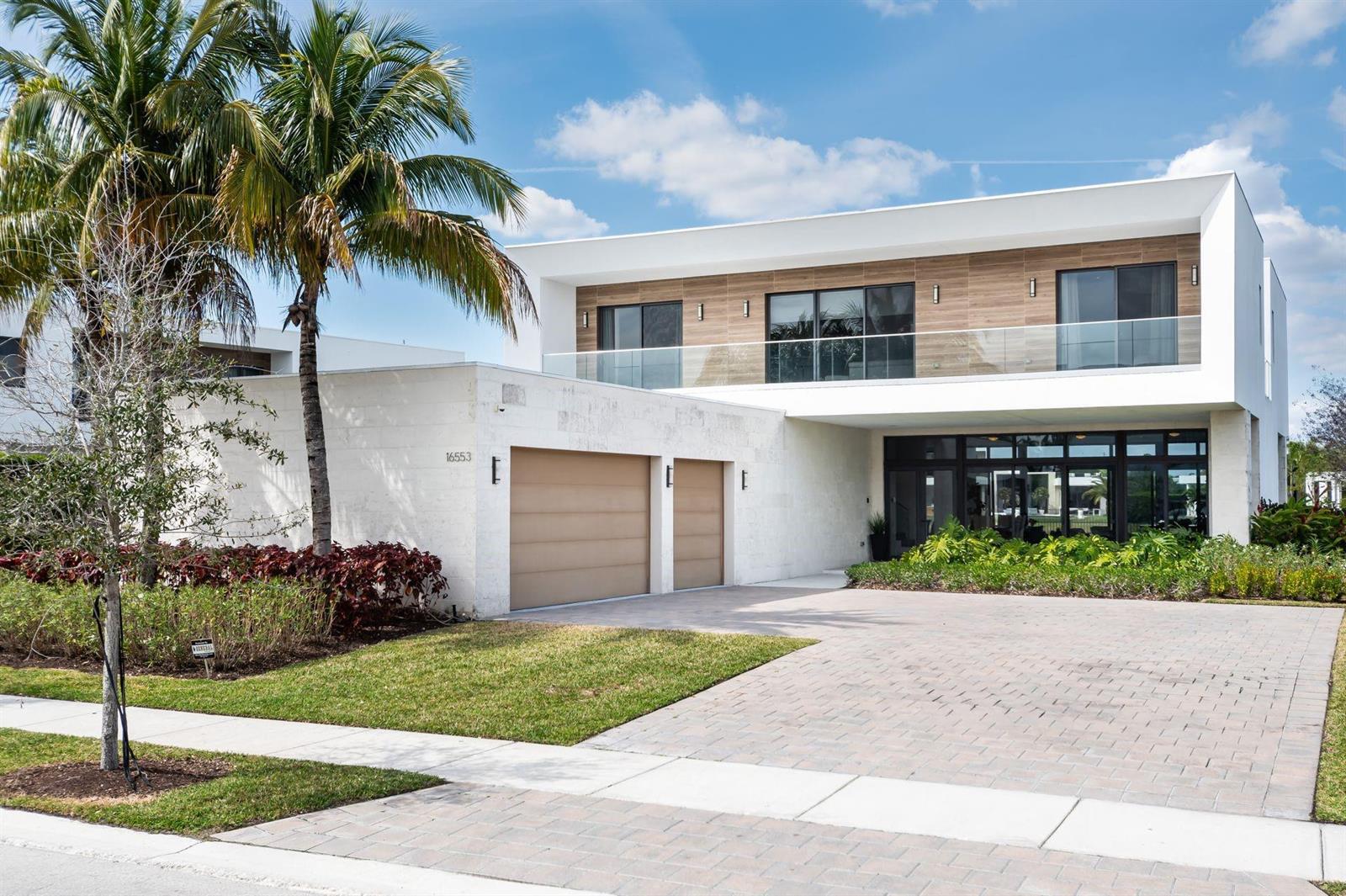 A modern two-story house features a white stone exterior, wood-paneled upper level, and attached garage — 16553 Botaniko Drive S, Weston FL 33326, WESTON, FL