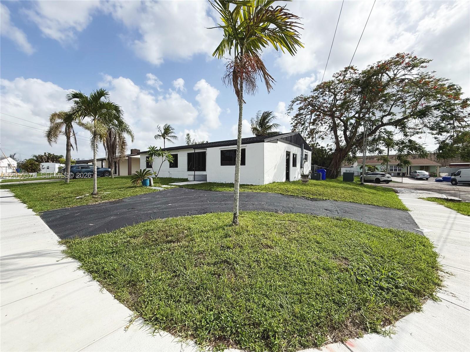 A white single-story house features a black asphalt driveway and palm trees in the yard — 2401 SW 50th Ter, Plantation FL 33317, PLANTATION, FL