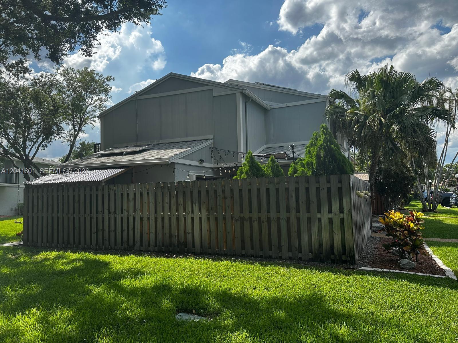 A gray two-story house with a wooden fence and a palm tree in the yard — 13290 NW 7th St, Plantation FL 33325, PLANTATION, FL