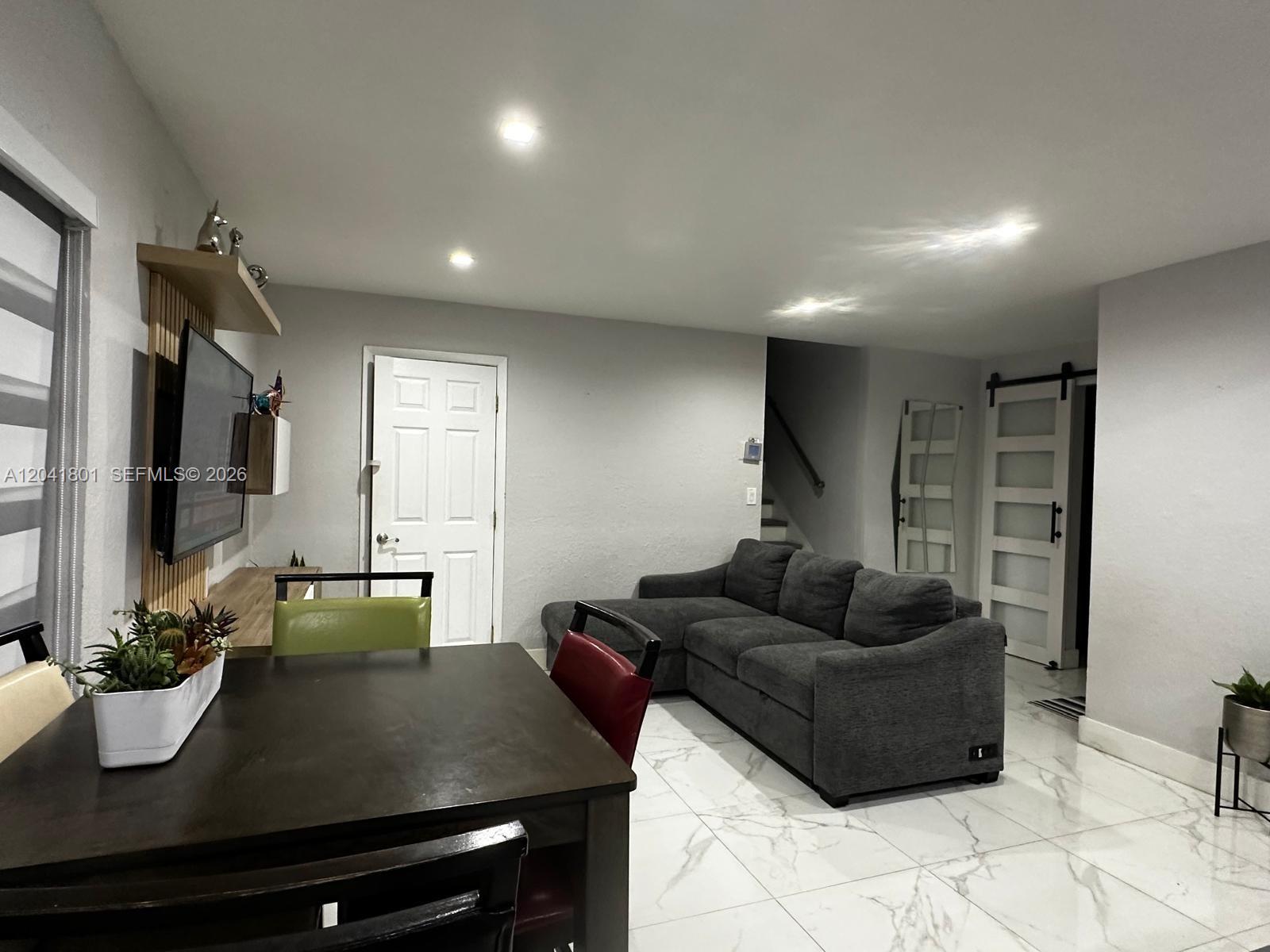 A living and dining area features white marble-look tile flooring and a gray sectional sofa — 13290 NW 7th St, Plantation FL 33325, PLANTATION, FL