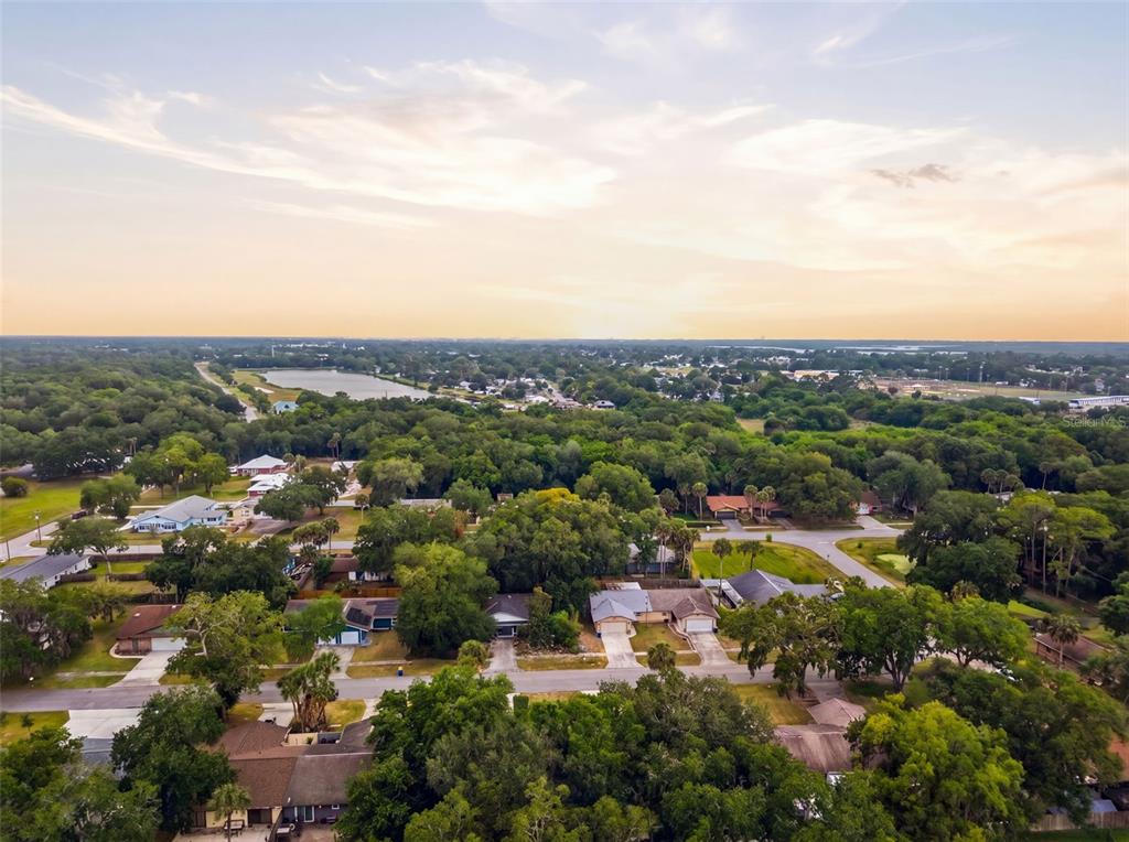 An aerial view shows a house with a shingled roof, a driveway, and surrounding landscaping — 1302 BOND STREET, EDGEWATER, FL