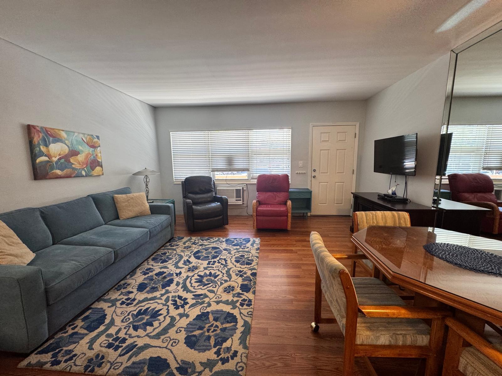 A living and dining area features a blue sofa, two recliners, and wood-look flooring — 2001 S Ocean Drive # 46, Hallandale Beach FL 33009, HALLANDALE BEACH, FL