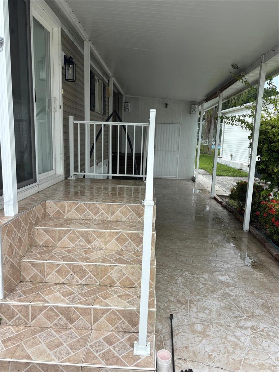 A tiled staircase leads to a covered porch with a white metal railing — 5116 NW 4th Avenue, Deerfield Beach FL 33064, DEERFIELD BEACH, FL