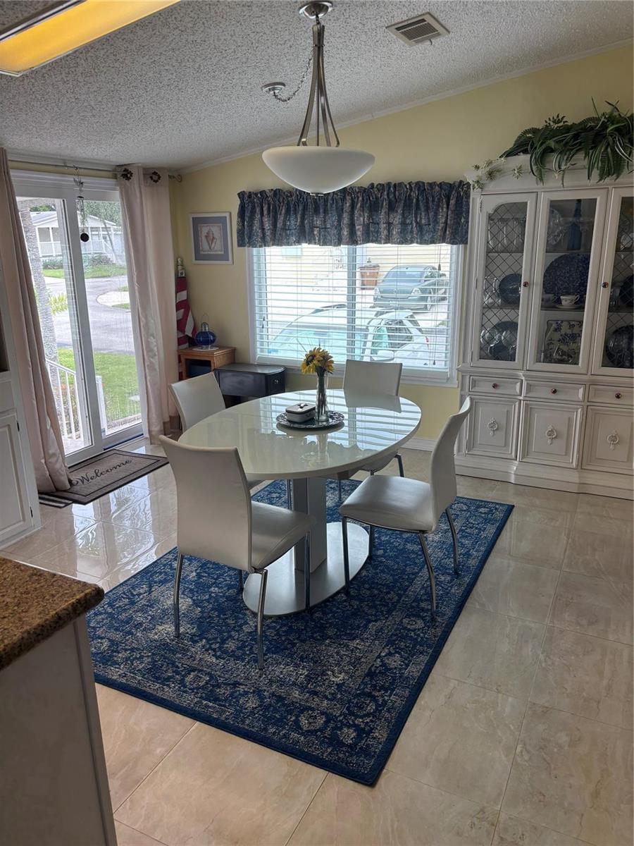 A dining area features a white oval table, four chairs, a blue rug, and a hutch — 5116 NW 4th Avenue, Deerfield Beach FL 33064, DEERFIELD BEACH, FL