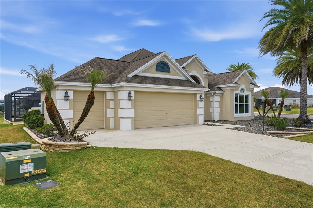 A tan single-story house with a three-car garage and a screened-in pool area — 1166 BLOUNT AVENUE, THE VILLAGES, FL