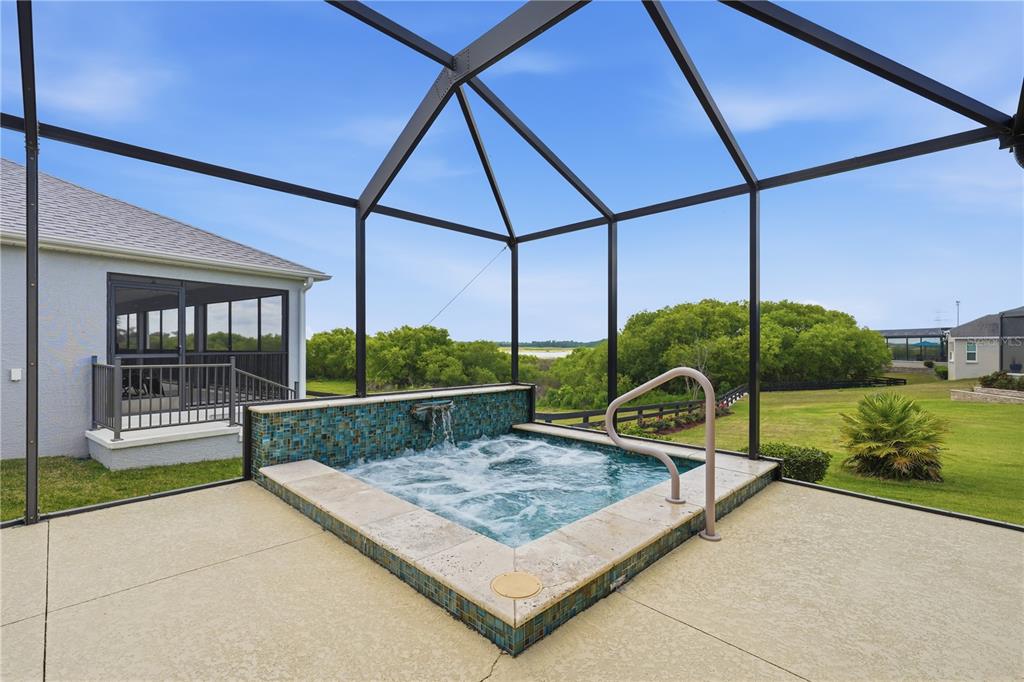 A screened-in patio features a raised hot tub with blue tile and stone coping — 1166 BLOUNT AVENUE, THE VILLAGES, FL