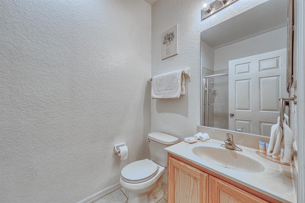 A small bathroom features a light wood vanity, a toilet, and a wall-mounted towel rack — 2759 CORVETTE LANE, KISSIMMEE, FL