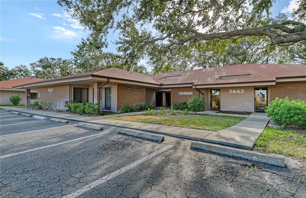 A single-story commercial building with a brick facade, a parking lot, and mature oak trees — 3657 CORTEZ ROAD W UNIT 130, BRADENTON, FL