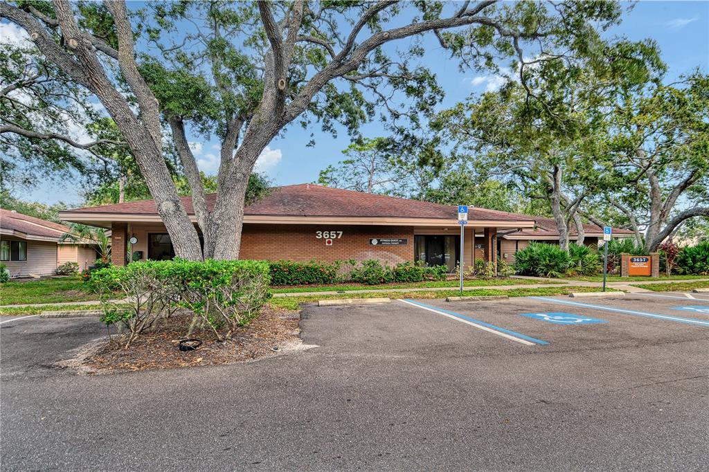 A single-story brick commercial building features a low-pitched roof and a paved parking lot — 3657 CORTEZ ROAD W UNIT 130, BRADENTON, FL