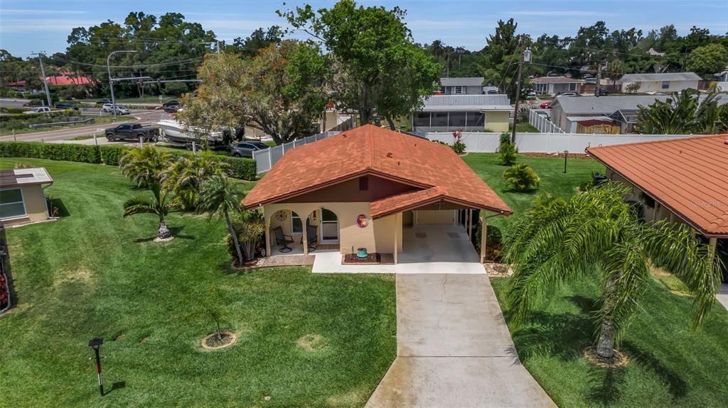 An aerial view of a single-story house with a red roof, carport, and front porch — 3311 MERCER ROAD UNIT 3311, BRADENTON, FL