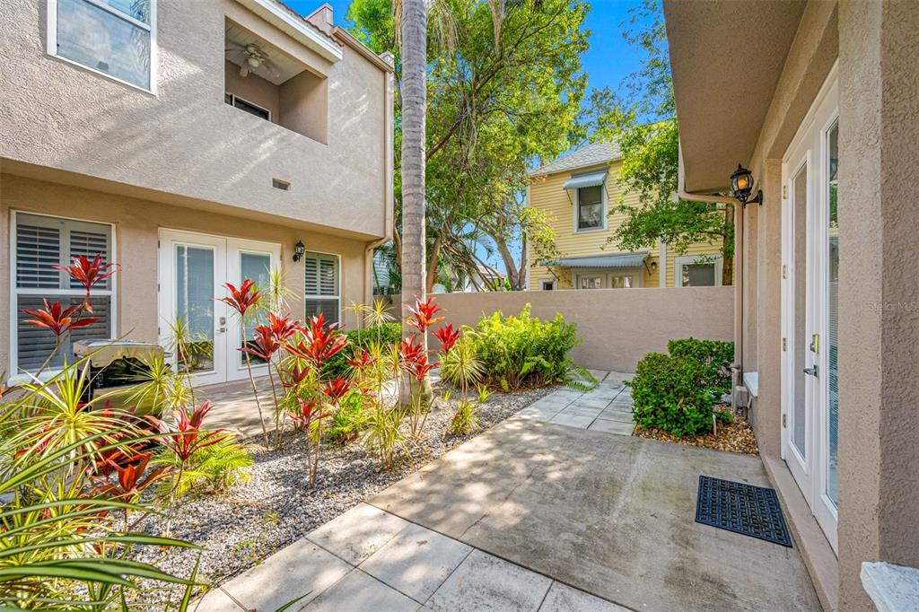 A tan, three-bay garage with one open door and a brick driveway — 237 7TH AVENUE N UNIT 2, ST PETERSBURG, FL