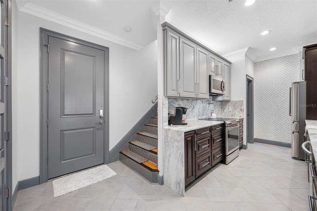 A kitchen features dark wood cabinets, marble countertops, stainless steel appliances, and a large island — 237 7TH AVENUE N UNIT 2, ST PETERSBURG, FL