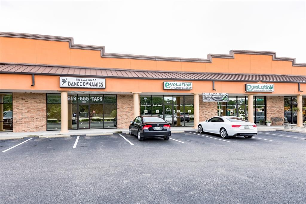 A strip mall features three storefronts with orange stucco walls and a parking lot — 4325 LYNX PAW TRAIL UNIT 4325, VALRICO, FL