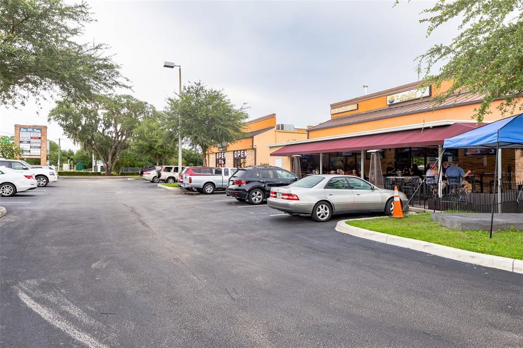 A parking lot sits in front of a commercial building with a restaurant patio — 4325 LYNX PAW TRAIL UNIT 4325, VALRICO, FL