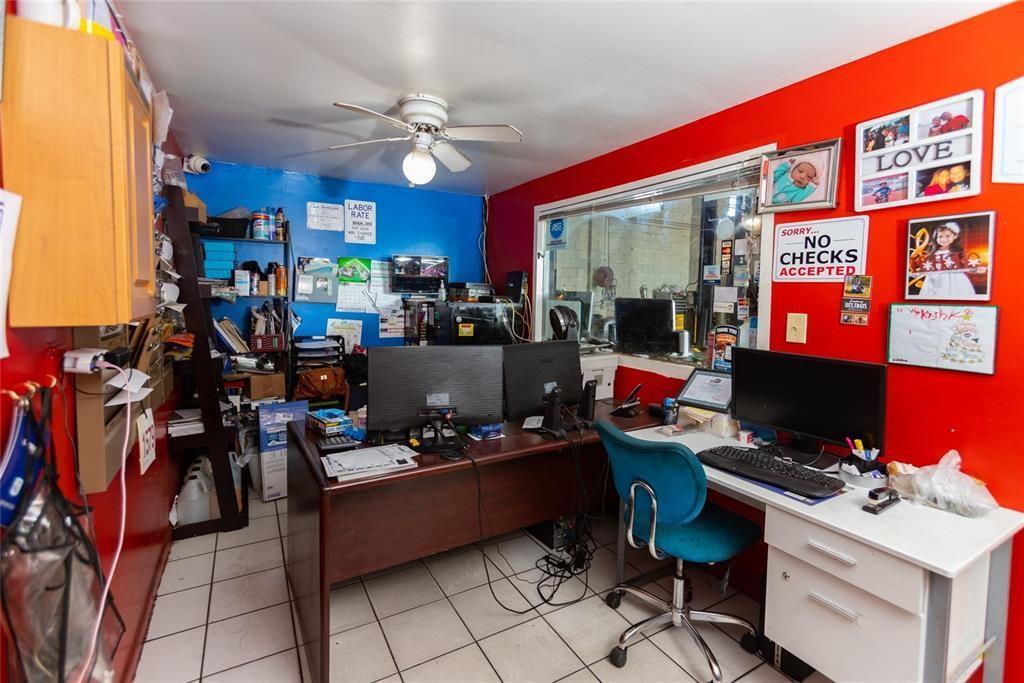 A small office space features a dark wood desk, computer monitors, and bright red walls — 669 NW 26th Street, Miami FL 33127, MIAMI, FL