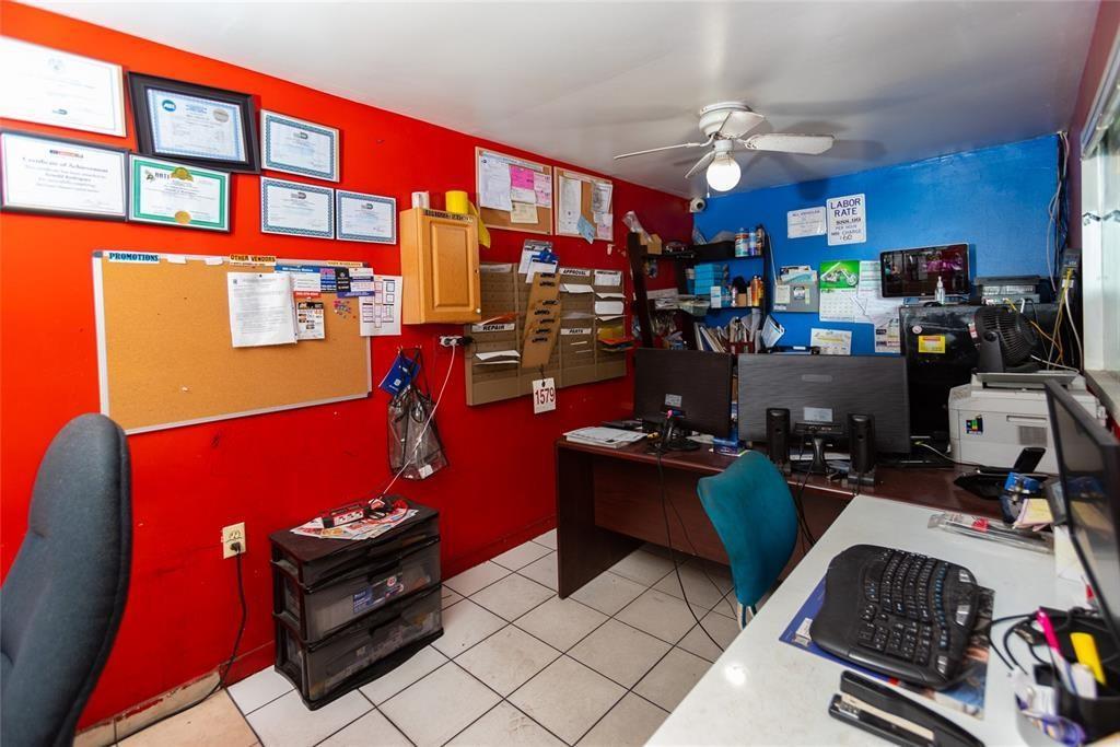 An office space features red and blue walls, a desk with computers, and tiled flooring — 669 NW 26th Street, Miami FL 33127, MIAMI, FL