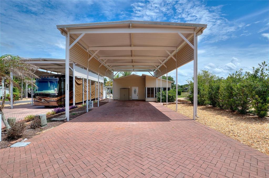 A paved driveway leads to a covered carport and the entrance of a residential home — 2336 ST GEORGE DRIVE, DAVENPORT, FL