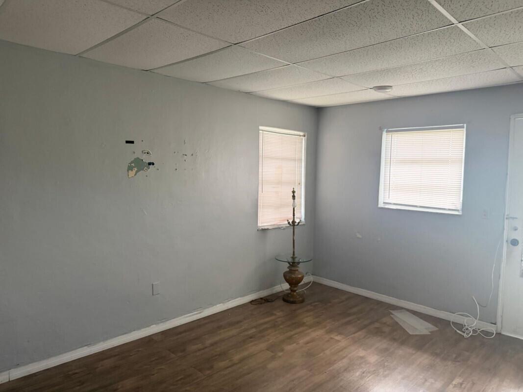 An empty room with light blue walls, wood-look flooring, and a drop ceiling — 88 NW 18th Avenue, Miami FL 33125, MIAMI, FL