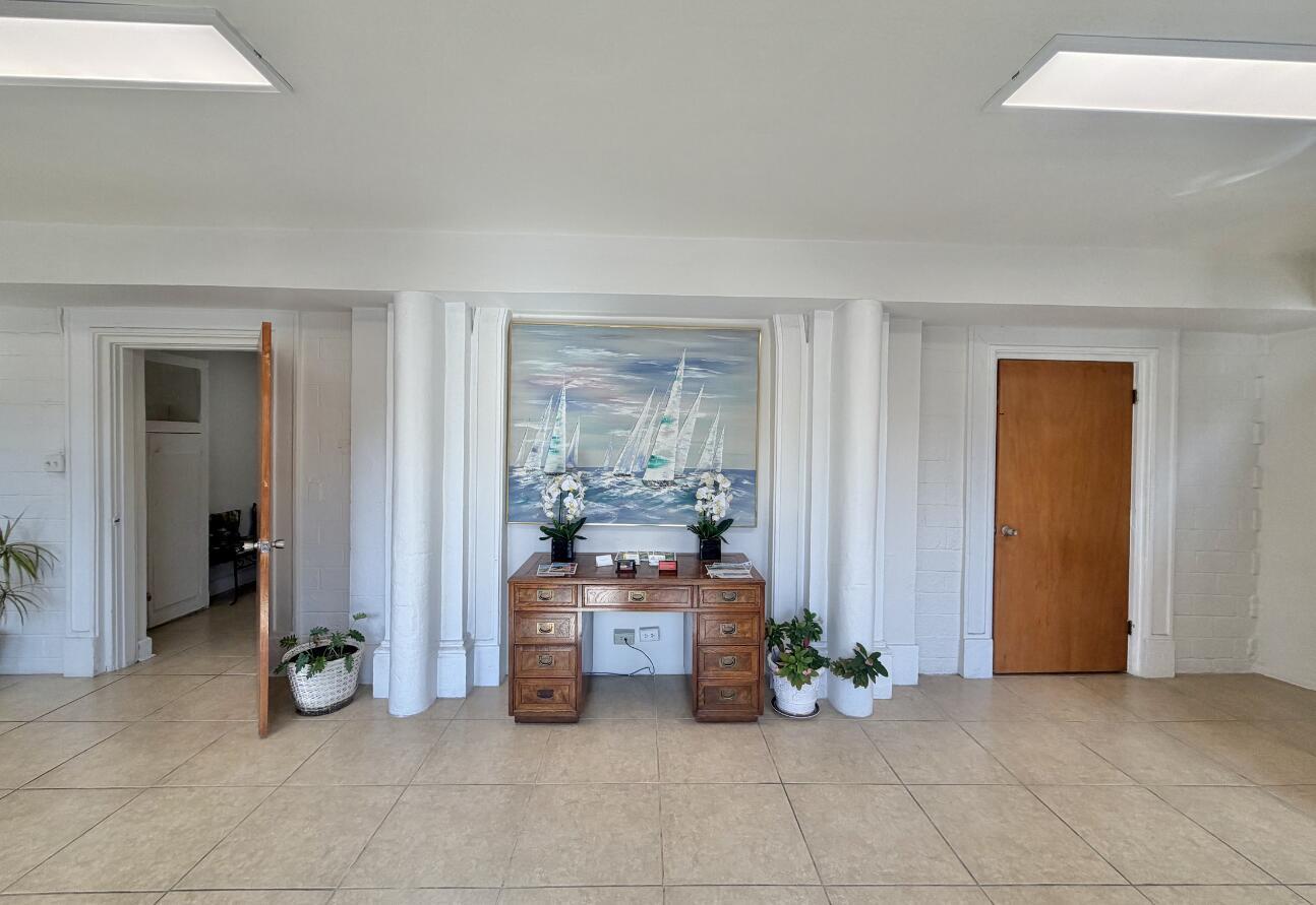 A room with tile floors, two wooden doors, and a desk centered beneath a painting — 3600 Broadway, West Palm Beach FL 33407, WEST PALM BEACH, FL