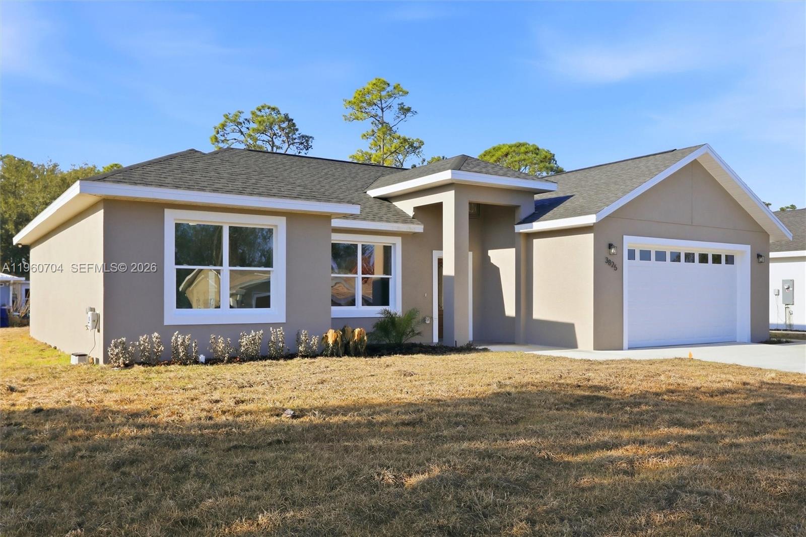 A single-story house with a beige stucco exterior, a gray shingled roof, and a garage — 3825 Citroen Dr, Sebring FL 33872, SEBRING, FL