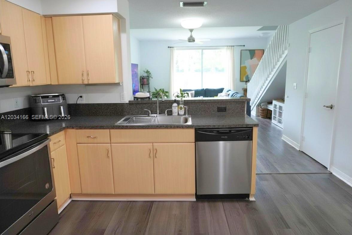 A kitchen features light wood cabinets, dark countertops, and stainless steel appliances — 1564 Veracruz Ln # 1564, Weston FL 33327, WESTON, FL