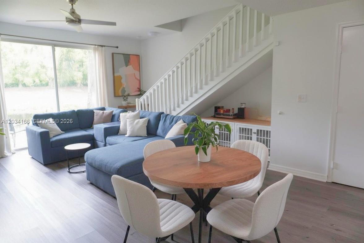 A living room features a blue sectional sofa, a round dining table, and a staircase — 1564 Veracruz Ln # 1564, Weston FL 33327, WESTON, FL