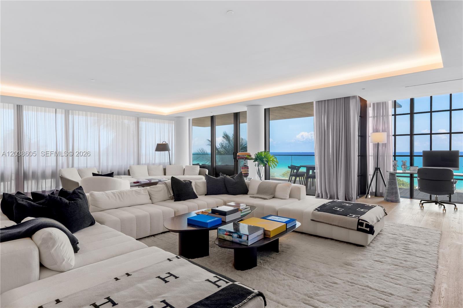 A spacious living room features a large white sectional, coffee tables, and floor-to-ceiling ocean views — 8955 E Collins Ave # 301, Surfside FL 33154, SURFSIDE, FL