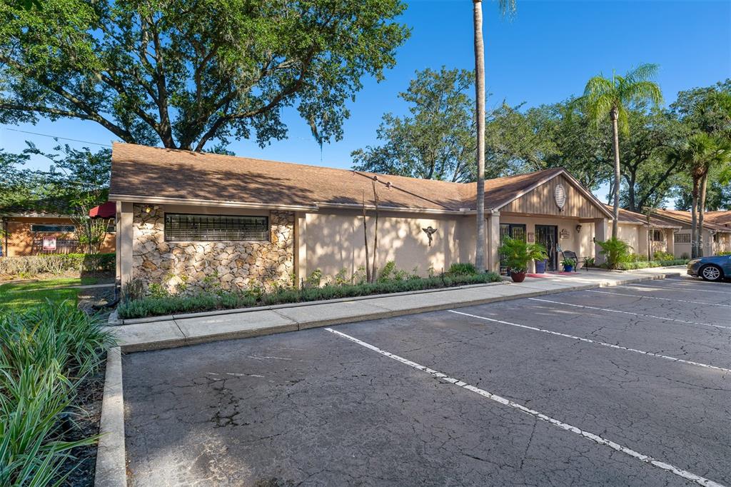 A single-story building with a stone facade and a parking lot in the foreground — 7210 CURRY FORD ROAD UNIT 2B, ORLANDO, FL