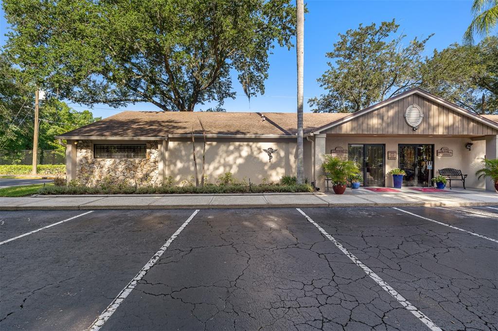 A single-story commercial building with a stone facade, brown roof, and a paved parking lot — 7210 CURRY FORD ROAD UNIT 2B, ORLANDO, FL