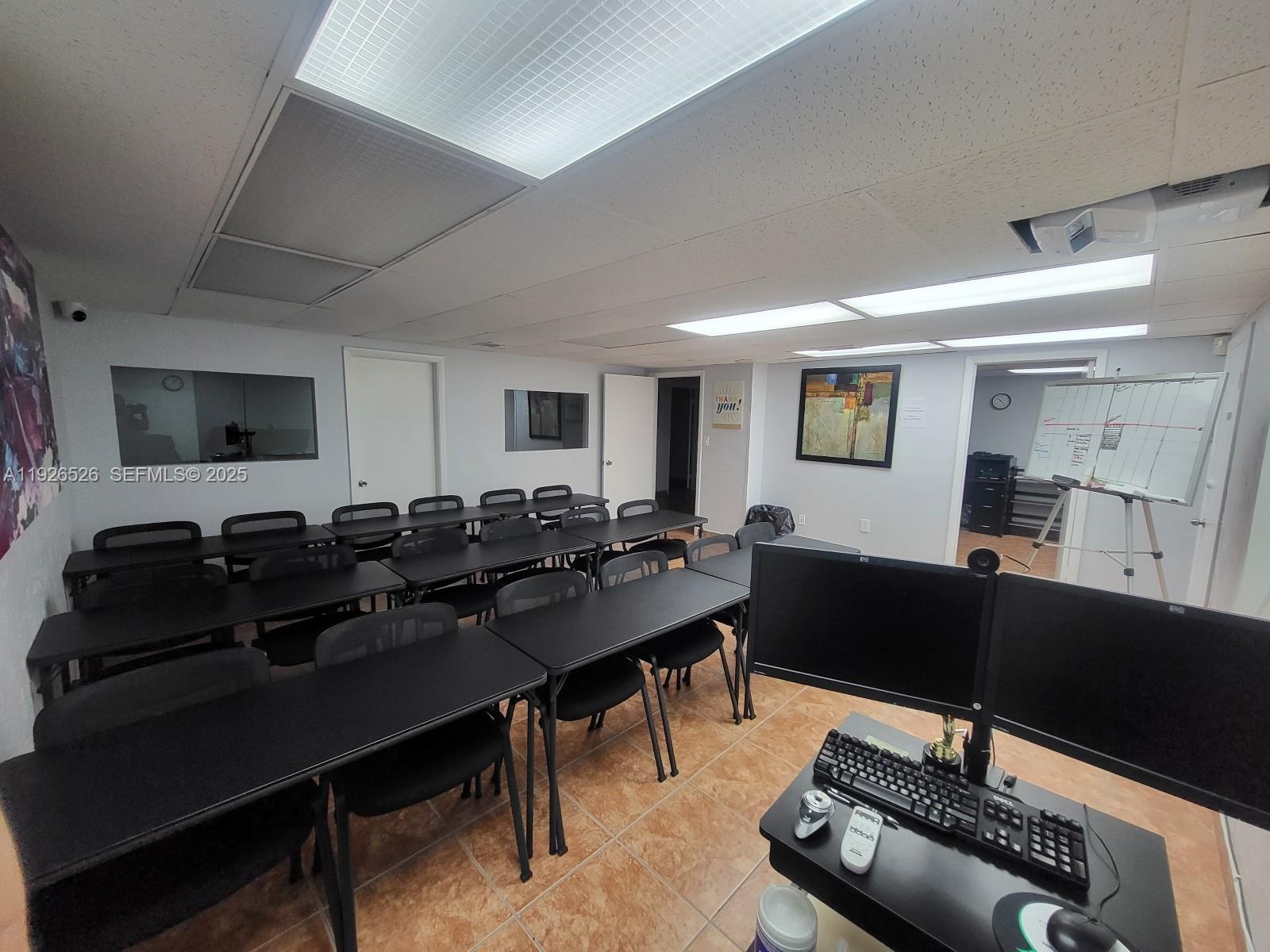 A classroom-style office space features rows of black desks, chairs, and dual computer monitors — 13499 Biscayne Blvd, North Miami FL 33181, NORTH MIAMI, FL