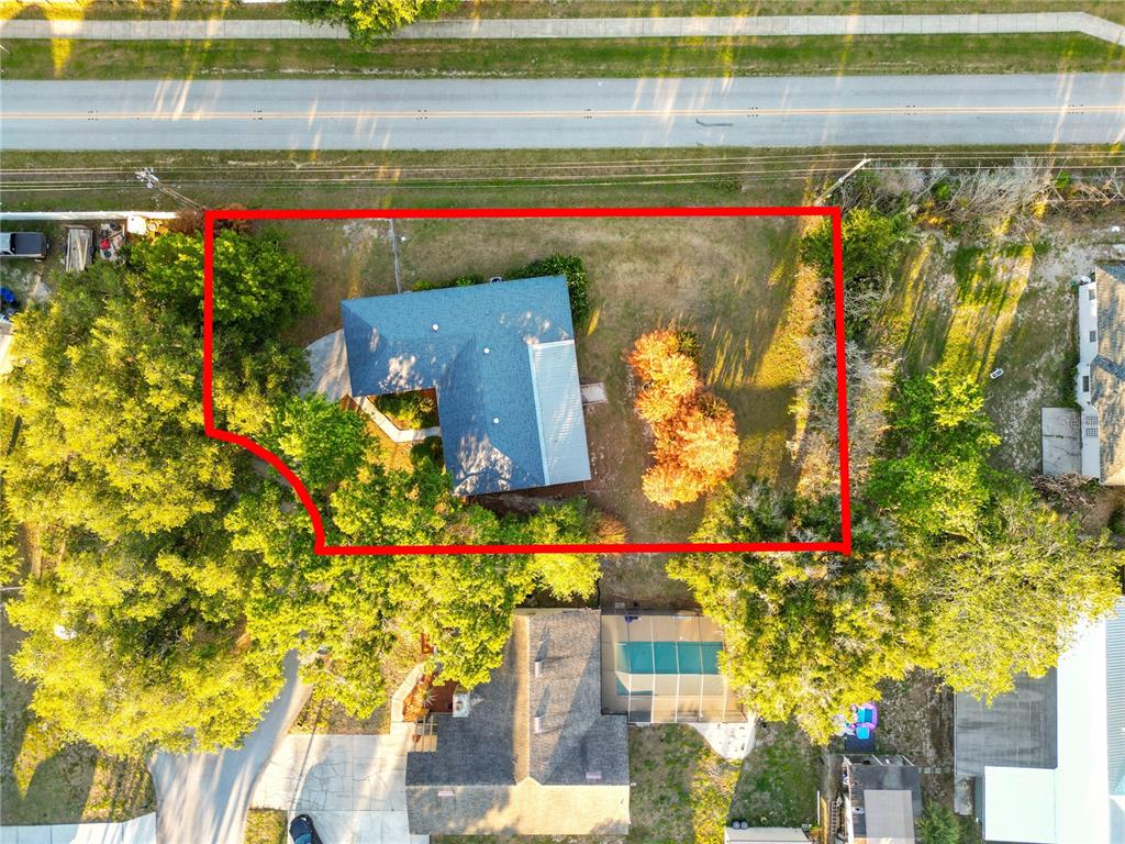 An aerial view shows a house with a blue roof on a tree-lined lot — 2304 CHESHIRE PLACE, LAKELAND, FL