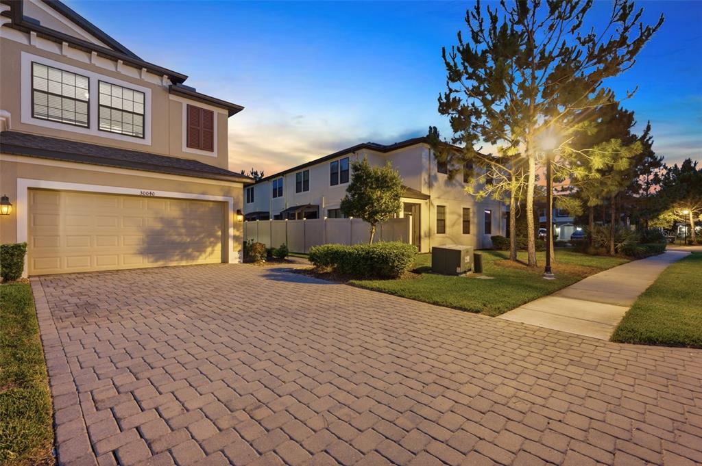 A paved driveway leads to a two-story house with a garage and adjacent sidewalk — 30040 SOUTHWELL LANE, WESLEY CHAPEL, FL