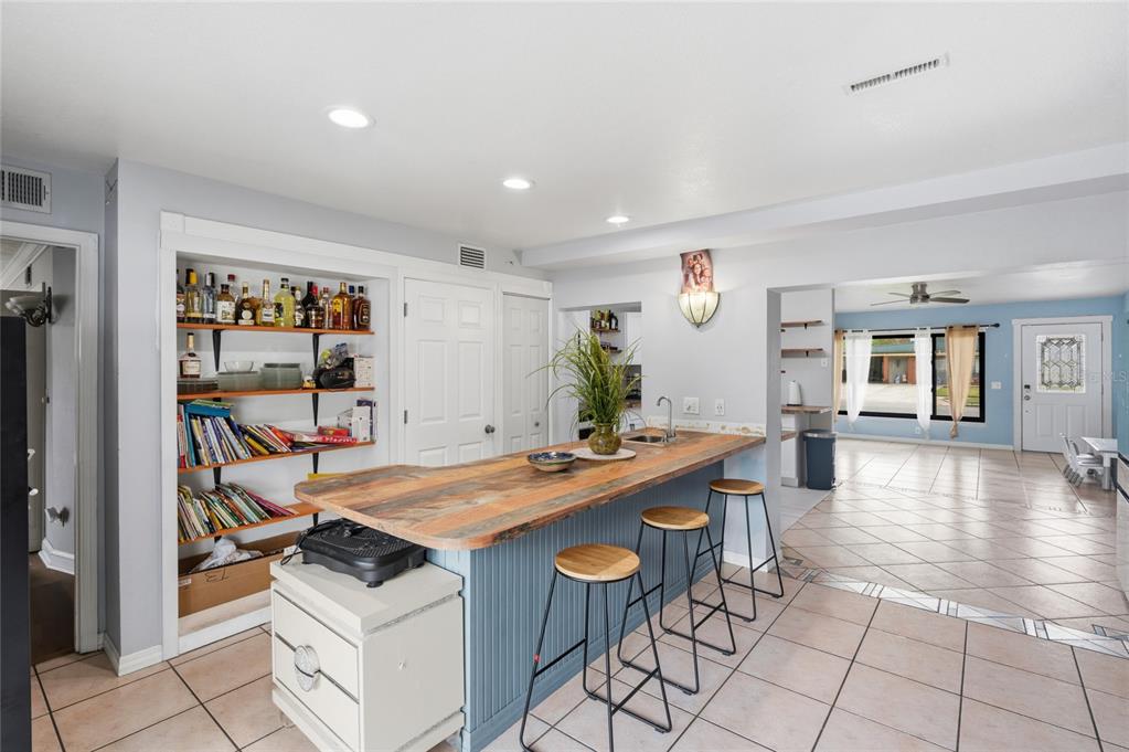 A kitchen island with a wood countertop and blue base sits in an open-concept room — 1307 BALTIMORE DRIVE, ORLANDO, FL