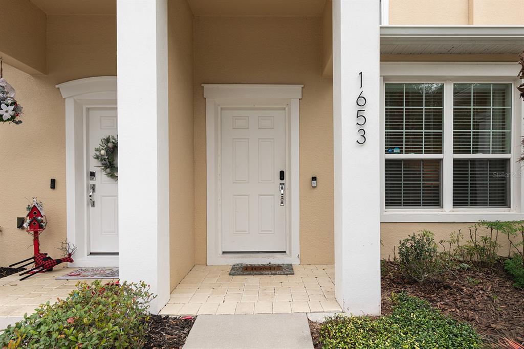 The exterior view shows two white front doors with wreaths and house number 1653 — 1653 RETREAT CIRCLE, CLERMONT, FL