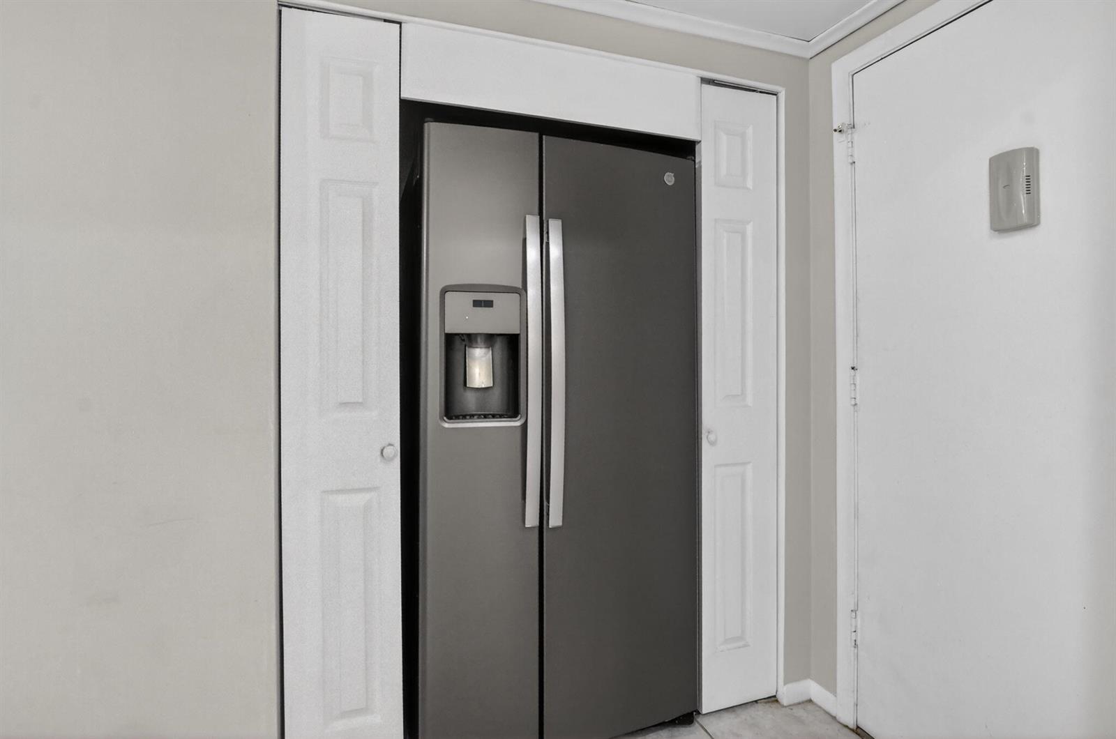 A stainless steel side-by-side refrigerator is recessed into a wall between two white closet doors — 250 NE 20th Street # 5220, Boca Raton FL 33431, BOCA RATON, FL