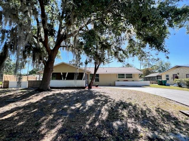 A single-story house with a large tree in the front yard under a blue sky — 424 VANNELL STREET, PORT CHARLOTTE, FL
