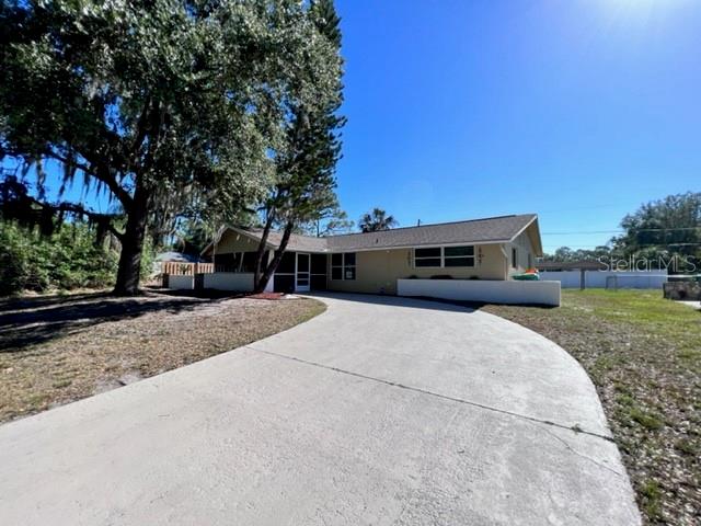 A single-story house with a concrete driveway and a large tree in the front yard — 424 VANNELL STREET, PORT CHARLOTTE, FL